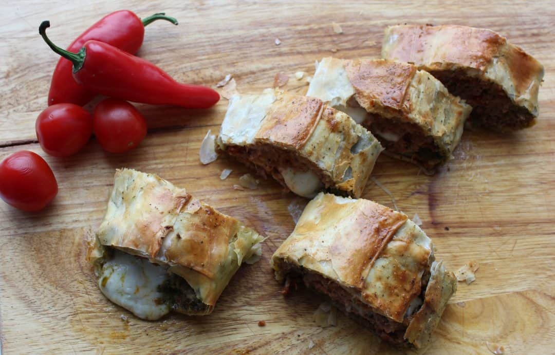 Slices of ground turkey sausage roll on a wooden cutting board