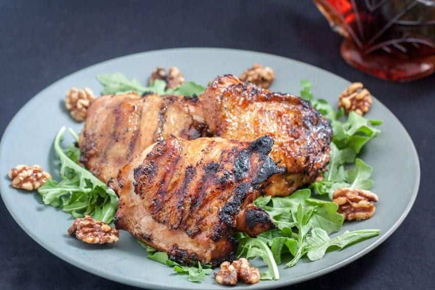 Maple glazed chicken thighs on a plate with salad.