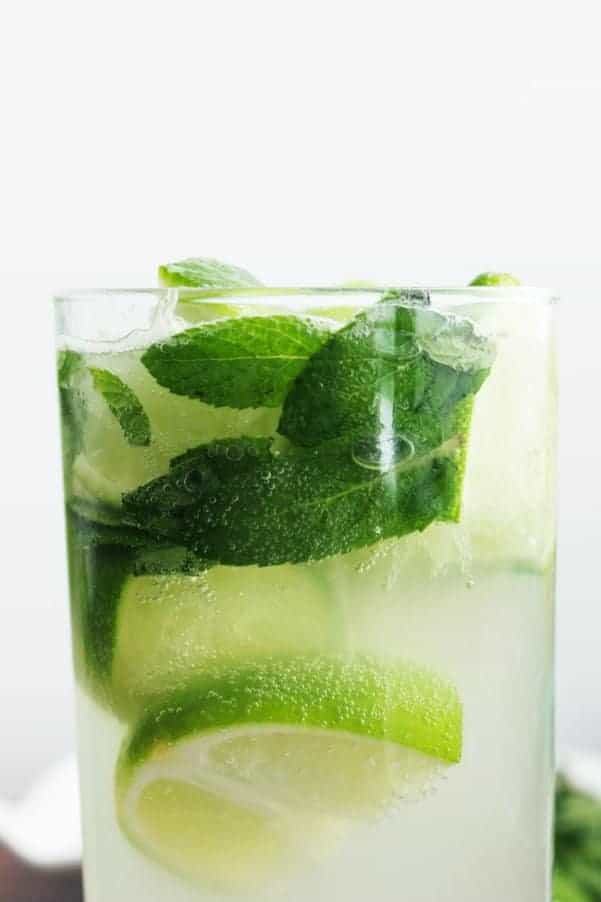 A closeup of a mojito elderflower cocktail on a white background