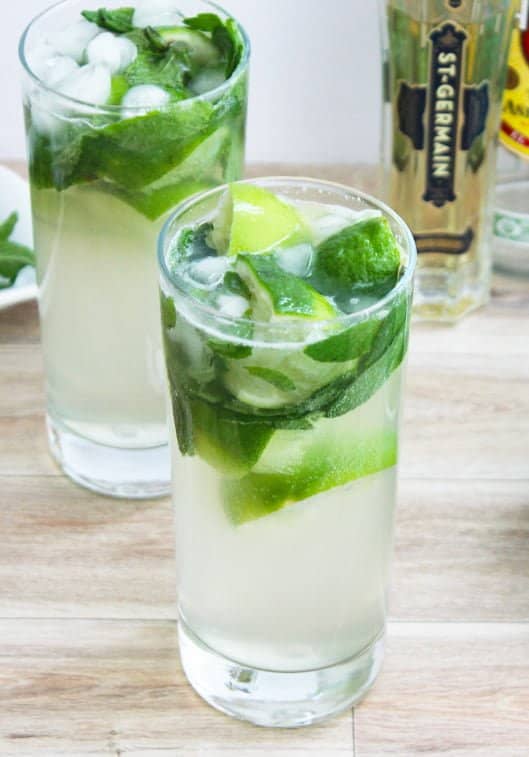 Two glasses of mojito elderfower cocktail on a wooden surface