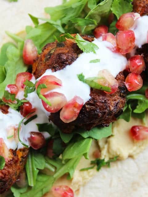 A closeup of lamb meatballs on a wrap with condiments