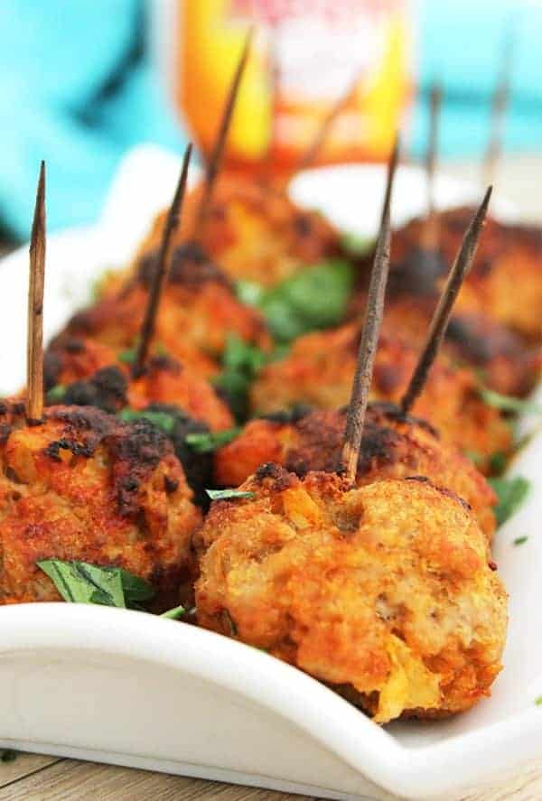 Closeup of baked pork meatballs on a white serving plate