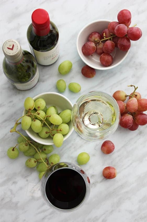 A top shot of two glasses of wine with grapes