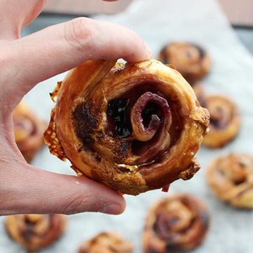 Close up of a sweet puff pastry pinwheel being held