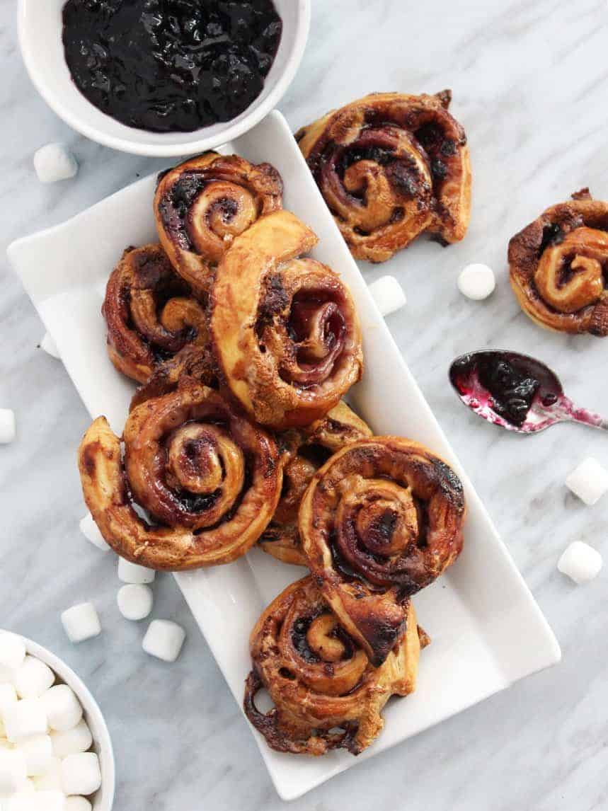 Top down shot of sweet puff pastry pinwheels on a white serving tray