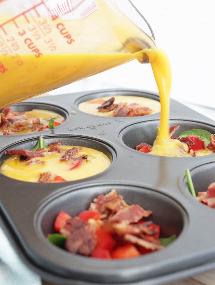 Egg mix being poured into a muffin pan