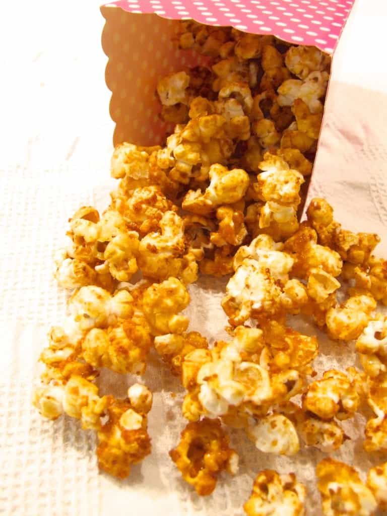 Apple and honey popcorn spilling out of a container