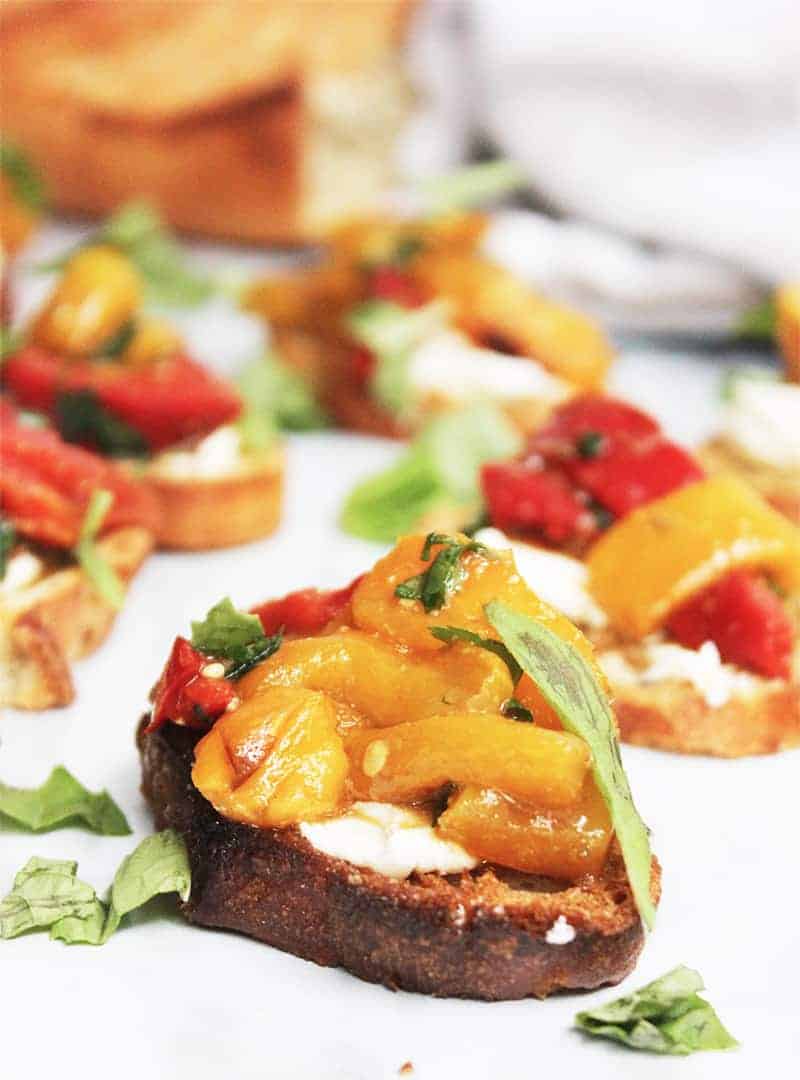 Close up of a topped crostini canape on a white work surface