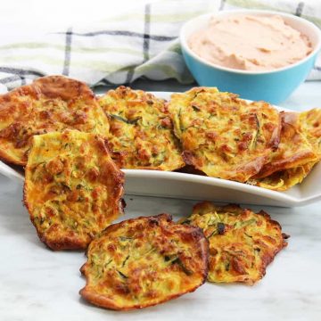 Baked zucchini fritters on a white serving dish