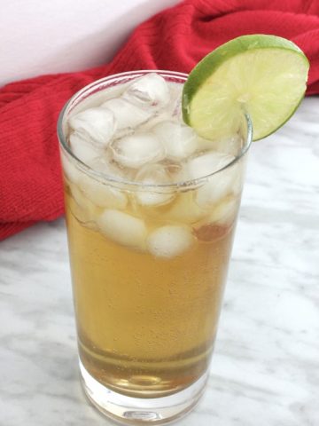 A spiced rum cocktail garnished with a slice of lime.