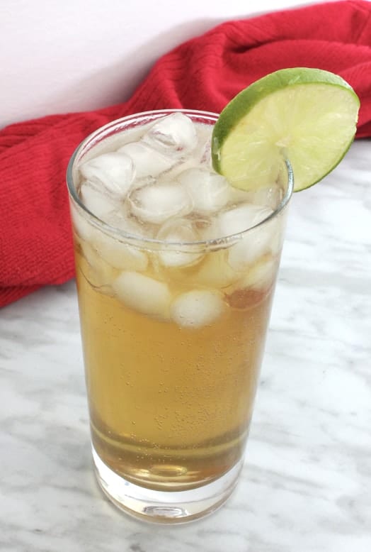 A spiced rum cocktail garnished with a slice of lime.