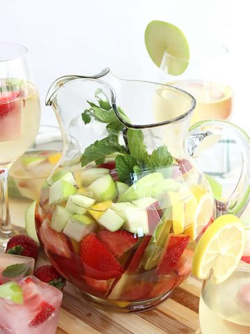 White wine sangria in a jug filled with fresh fruit and mint leaves