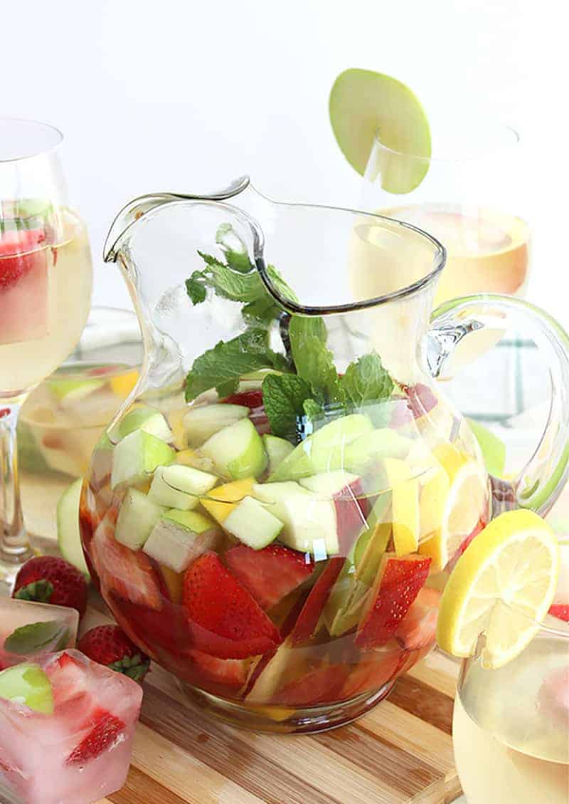 White wine sangria in a jug filled with fresh fruit and mint leaves