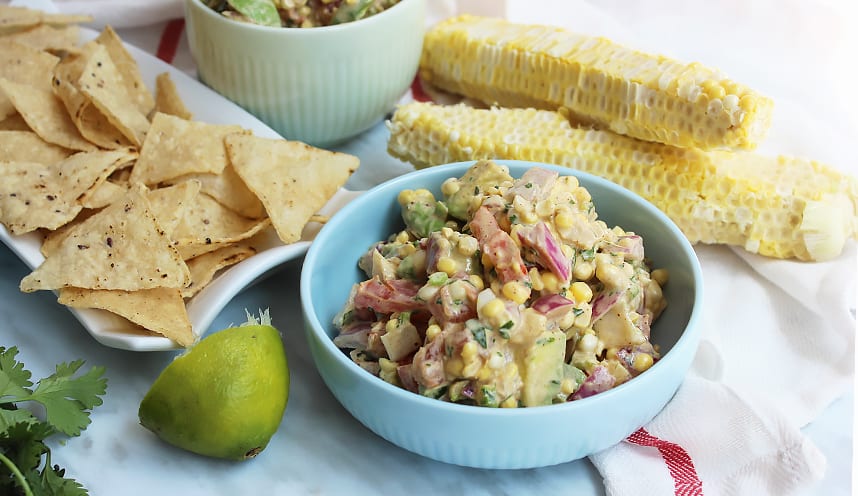 Salsa served in bowls with lime wedges and tortilla chips