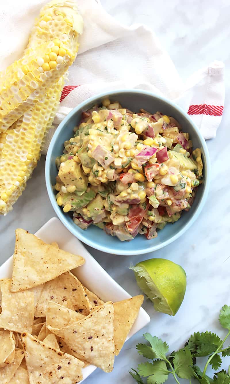 A bowl of corn salsa serves with tortilla chips