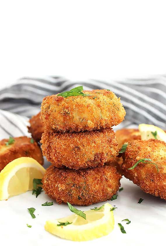 Stacked mini crab cakes garnished with fresh herbs