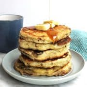 A stack of savory pancakes with butter and maple syrup