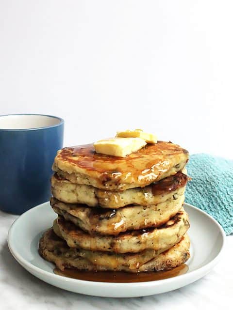 A stack of savory pancakes with a pat of butter on top