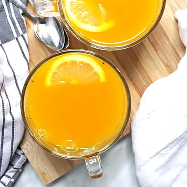 Turmeric tea in a glass cup with a slice of lemon