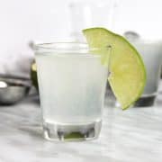 A gin shot with a slice of lime