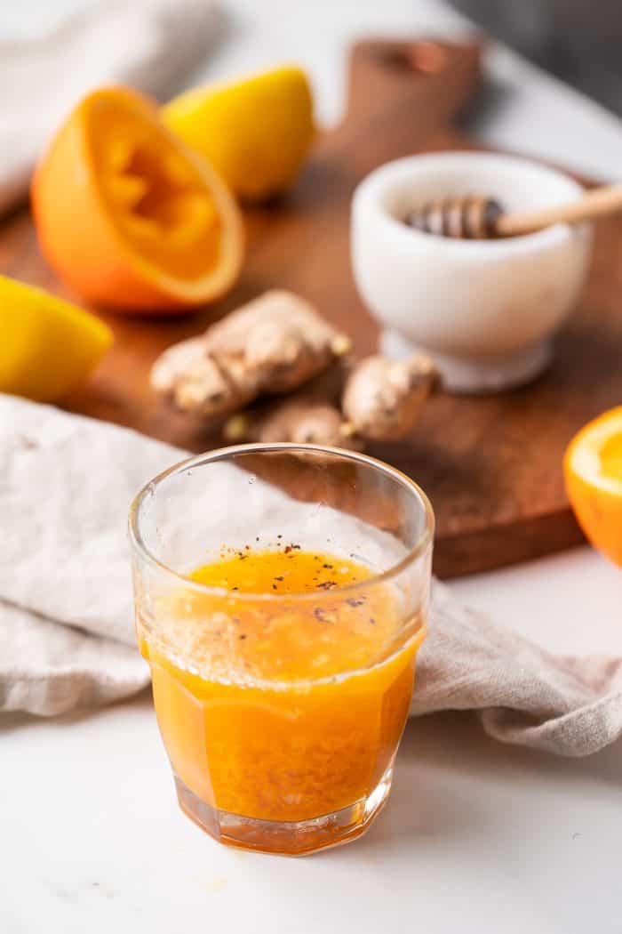 A turmeric shot in front of the ingredients to make it