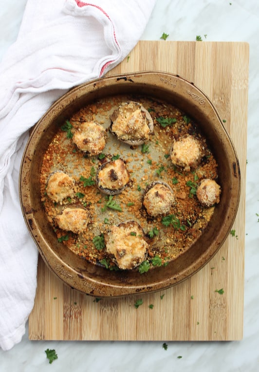 Baked stuffed mushrooms in a pan garnished with fresh herbs