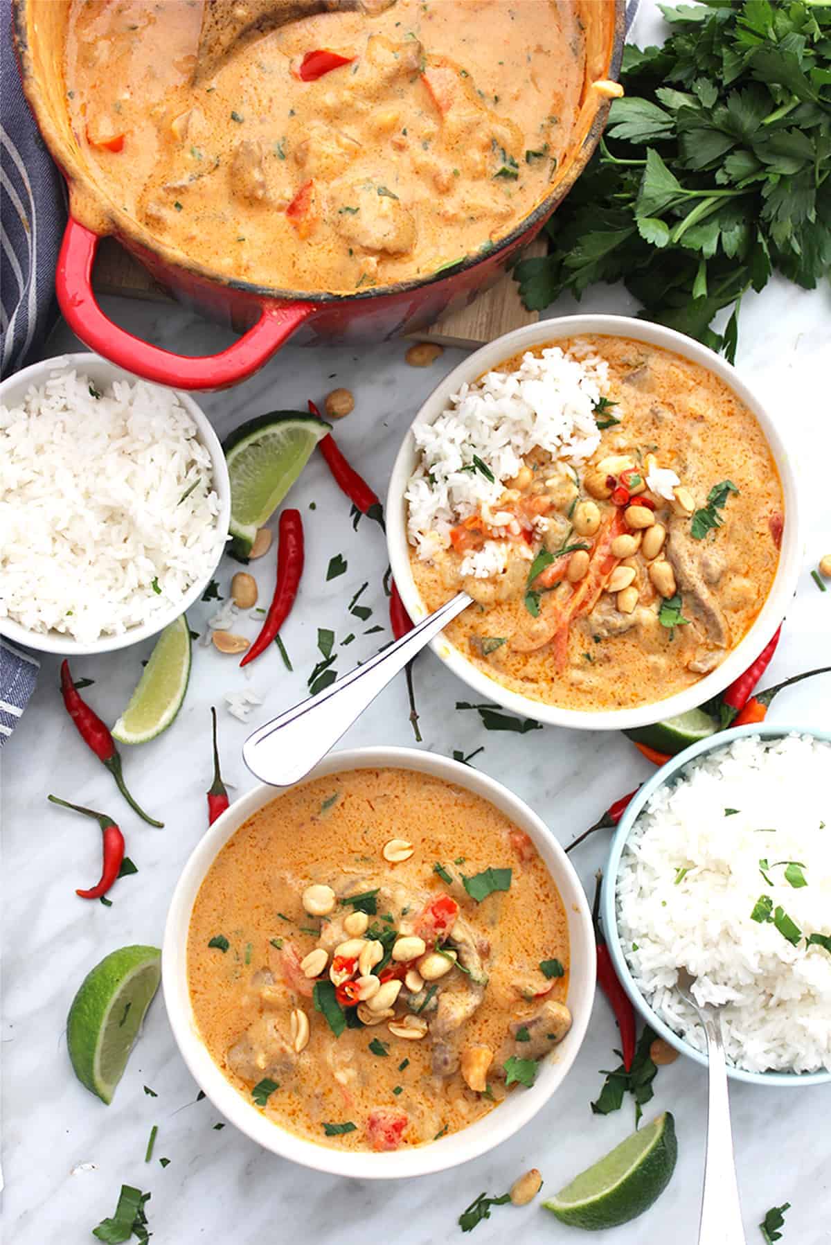 Two bowls of panang curry served from a dutch oven