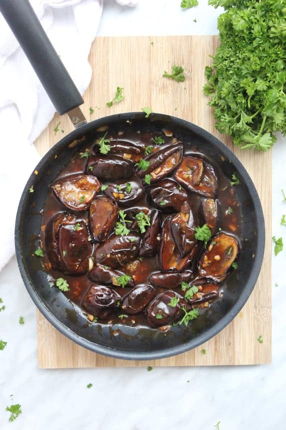 Stir fried baby eggplant in a frying pan