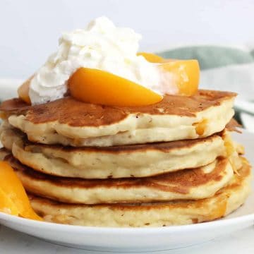 Peach pancakes topped with whipped cream