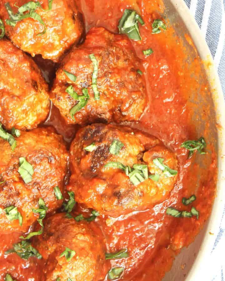 Bison meatballs in a skillet with tomato sauce