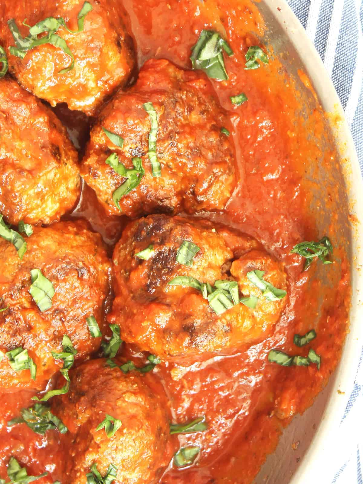 Bison meatballs in a skillet with tomato sauce