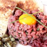Steak tartare served with toast and topped with an egg yolk
