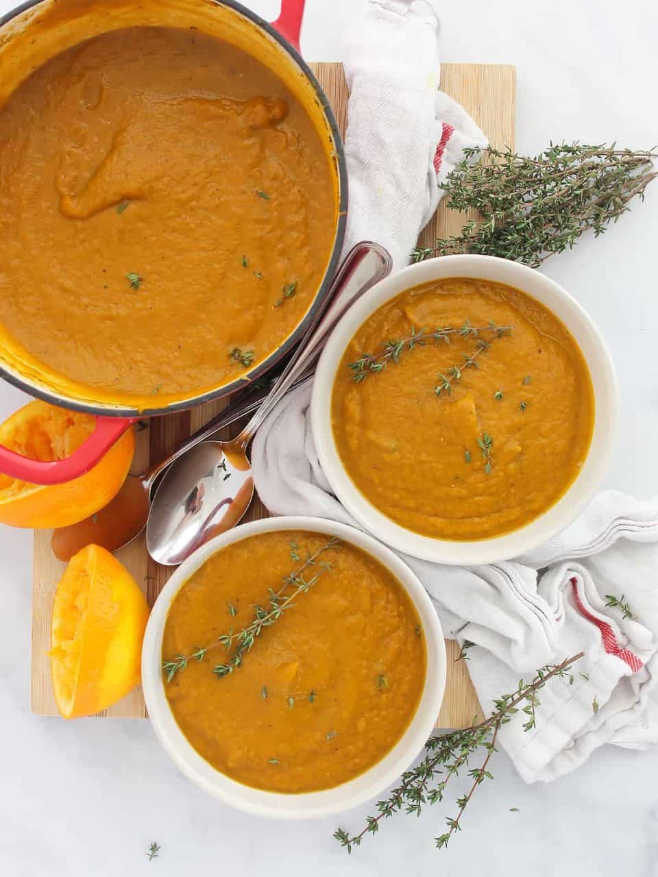 Carrot orange soup in a large pot and served into two bowls.