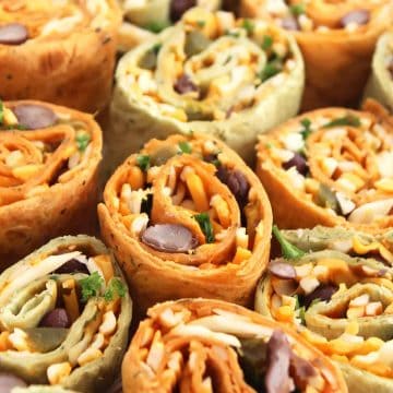 Close up of eight Mexican pinwheels filled with cheese and sprinkled with fresh cilantro.