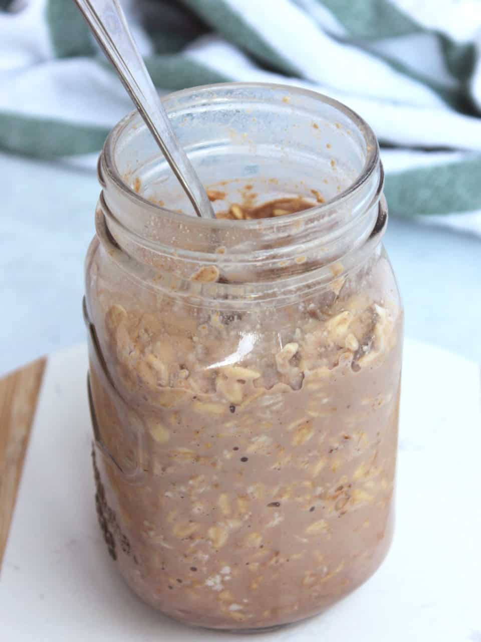 A spoon in a jar of overnight oats without topping.