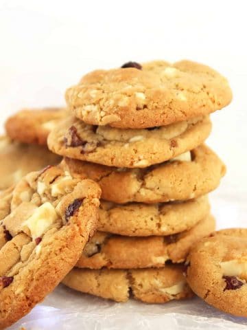 A stack of cookies with white chocolate chunks and cranberries.