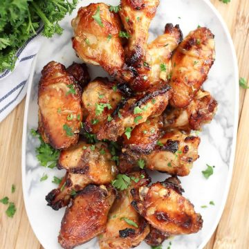 Glazed honey mustard chicken wings on a marble serving dish.