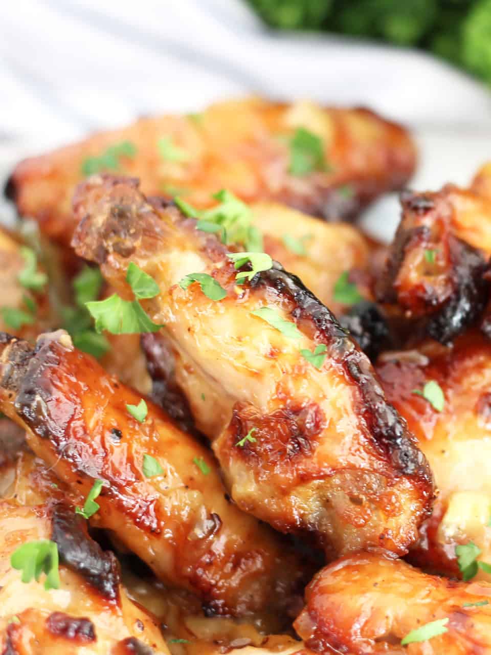 Close up of honey mustard chicken wings garnished with chopped parsley.