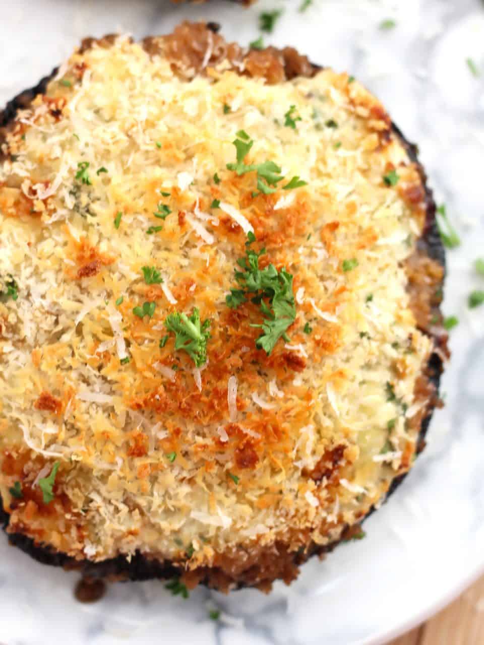 Top shot of a baked stuffed mushroom garnished with fresh parsley.