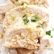 Close up of the sliced poached chicken drizzled with sauce.