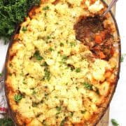 Ground beef and potato casserole with a serving spoon.