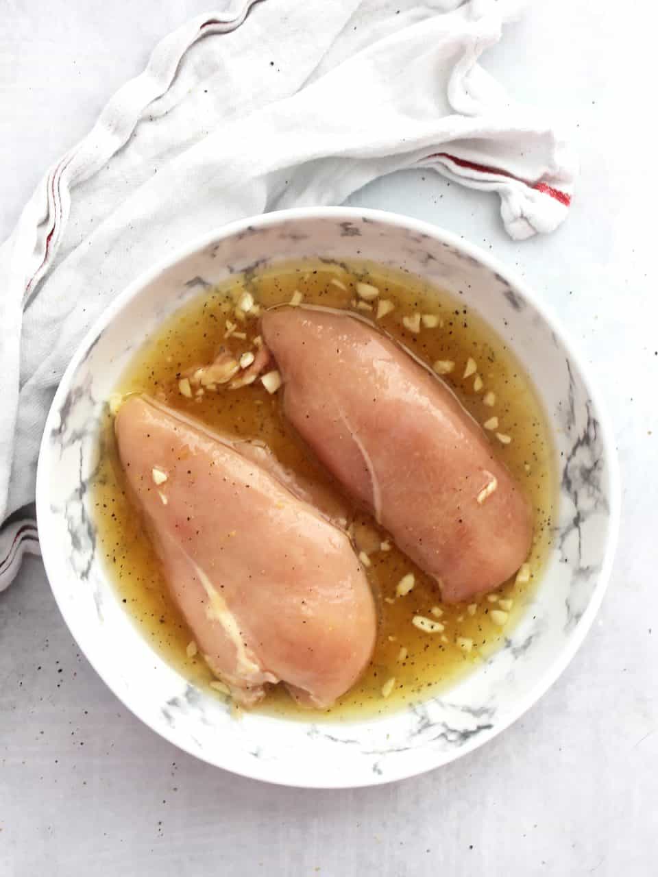 Tow chicken breasts being marinated in the lemon and honey sauce.