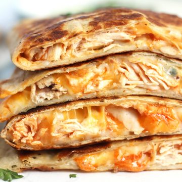 Close up of four buffalo chicken quesadillas stacked on top of each other.