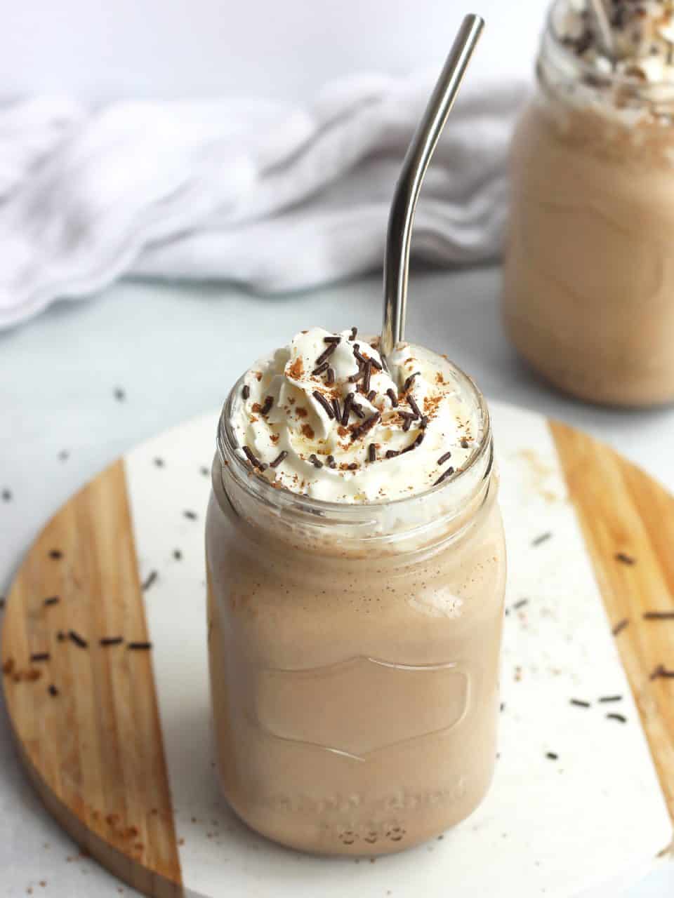 A metal straw in a mason jar filled with chocolate coffee milkshake.