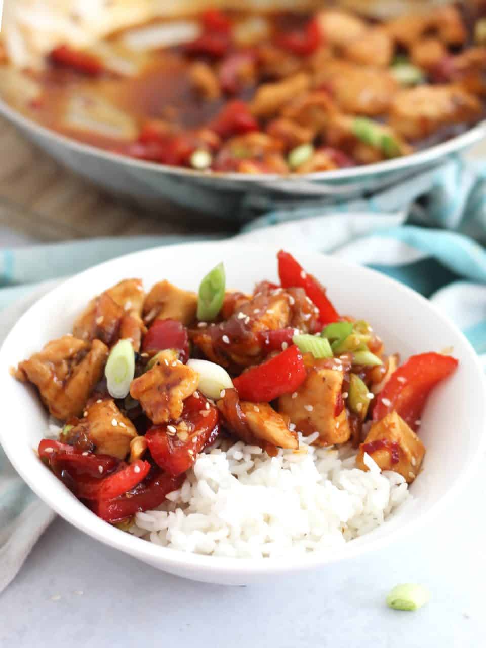 Honey sriracha chicken served in a bowl over rice.