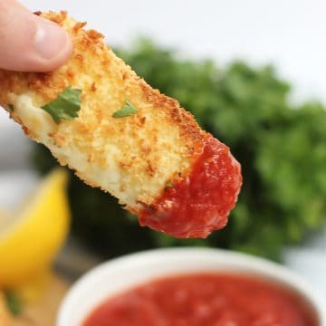 A halloumi fry dipped into a red sauce.