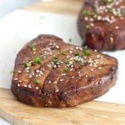 An air fried tuna steak garnished with sesame seeds and chopped chives.