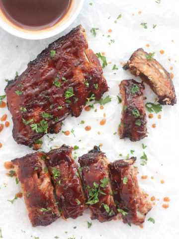 Overhead shot oven maple bbq oven roasted ribs drizzled with sauce.