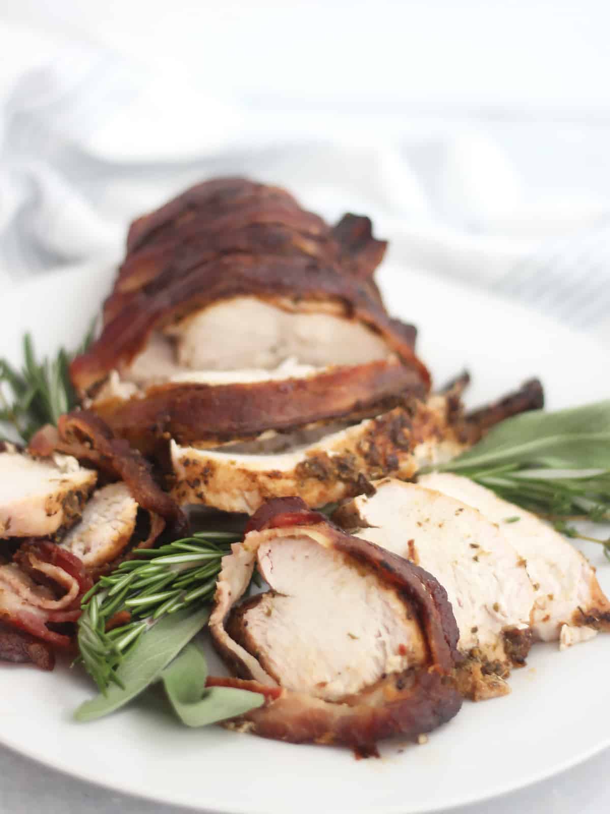Carved air fried turkey breast served on top of fresh rosemary and sage.
