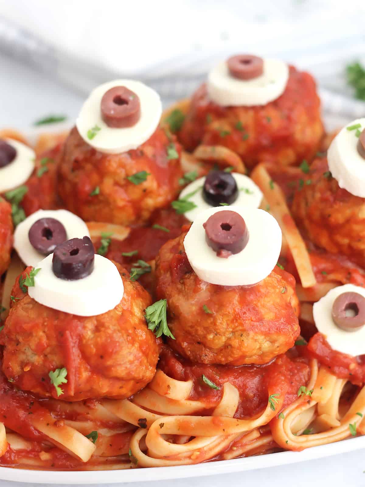 Creepy pasta meatballs garnished with fresh parsley.